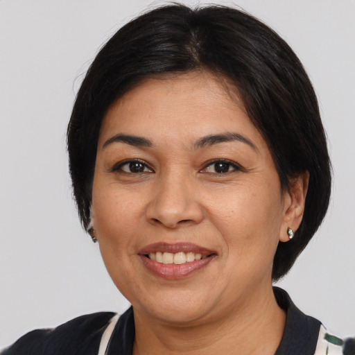 Joyful latino adult female with medium  black hair and brown eyes