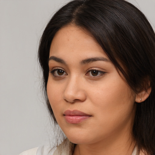 Joyful latino young-adult female with long  brown hair and brown eyes