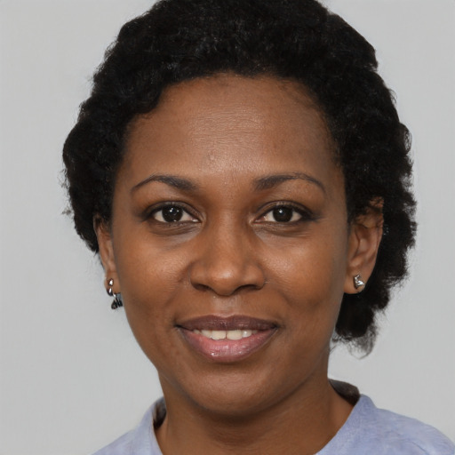 Joyful black adult female with short  black hair and brown eyes
