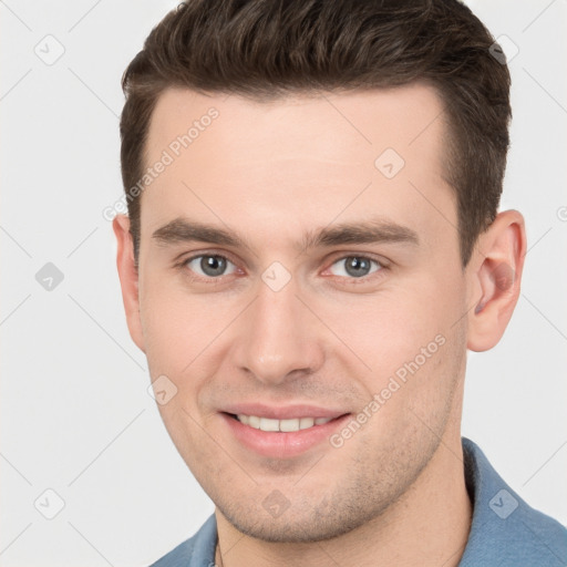 Joyful white young-adult male with short  brown hair and grey eyes