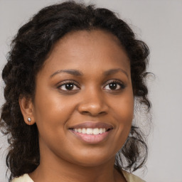 Joyful black young-adult female with long  brown hair and brown eyes