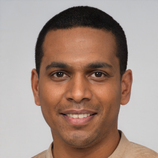 Joyful latino young-adult male with short  black hair and brown eyes