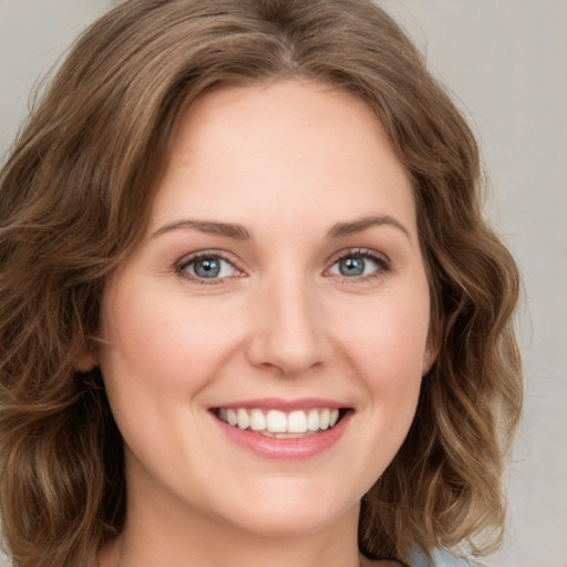 Joyful white young-adult female with medium  brown hair and green eyes