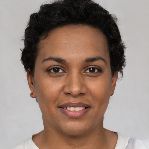 Joyful latino young-adult female with short  black hair and brown eyes