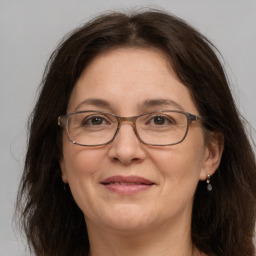 Joyful white adult female with long  brown hair and grey eyes