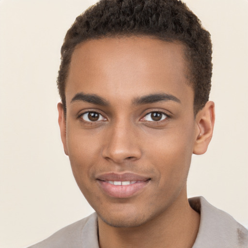 Joyful black young-adult male with short  brown hair and brown eyes