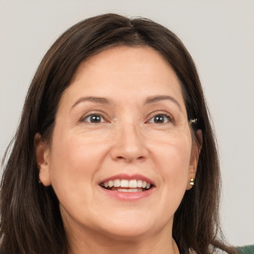 Joyful white adult female with long  brown hair and grey eyes