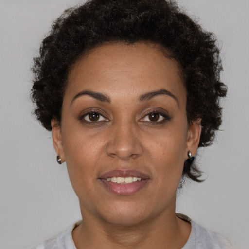 Joyful black adult female with short  brown hair and brown eyes