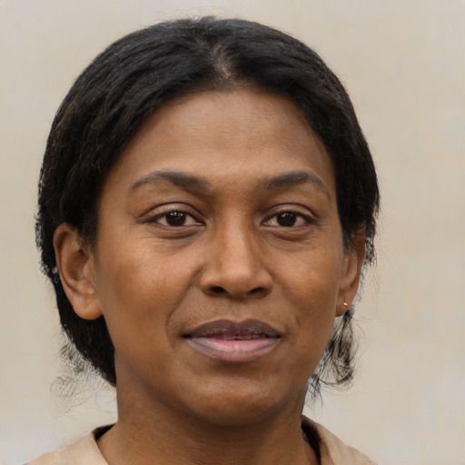 Joyful black young-adult female with medium  brown hair and brown eyes