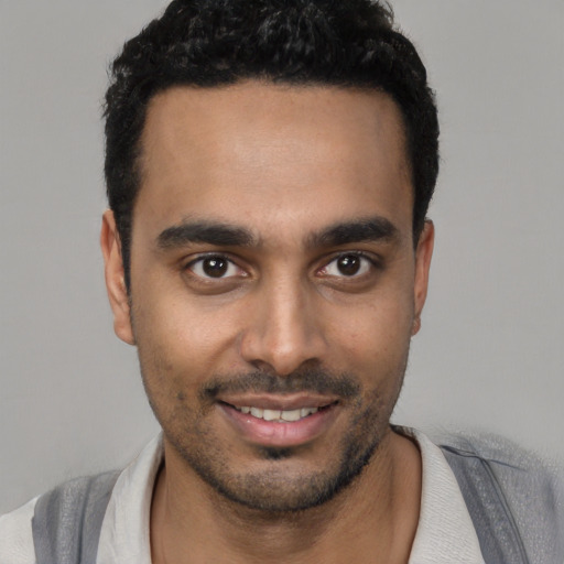 Joyful black young-adult male with short  black hair and brown eyes