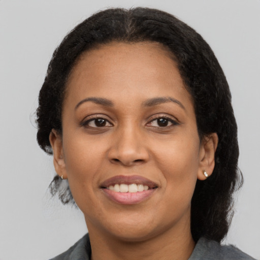 Joyful latino adult female with medium  black hair and brown eyes