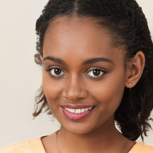 Joyful black young-adult female with long  brown hair and brown eyes