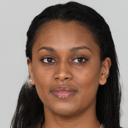 Joyful black young-adult female with long  black hair and brown eyes