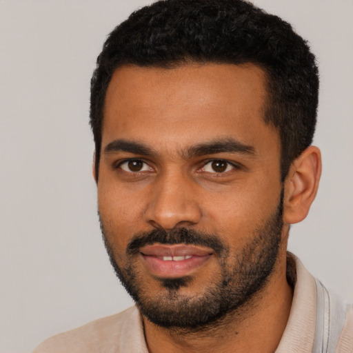 Joyful black young-adult male with short  black hair and brown eyes