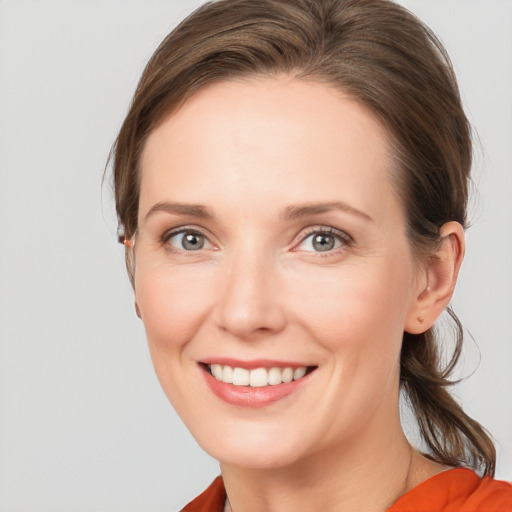 Joyful white young-adult female with medium  brown hair and blue eyes