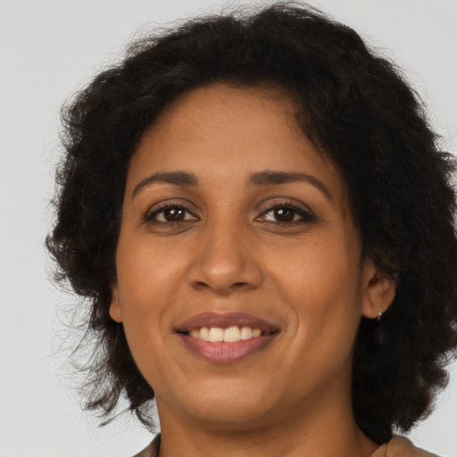 Joyful latino adult female with medium  brown hair and brown eyes