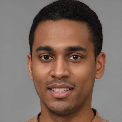 Joyful black young-adult male with short  black hair and brown eyes