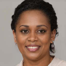 Joyful black adult female with short  brown hair and brown eyes