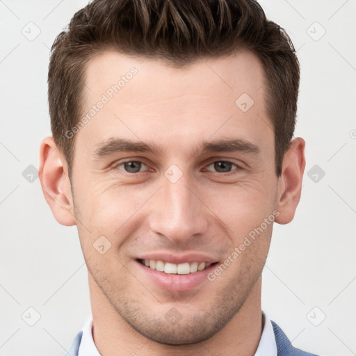 Joyful white young-adult male with short  brown hair and grey eyes