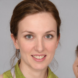 Joyful white young-adult female with medium  brown hair and grey eyes