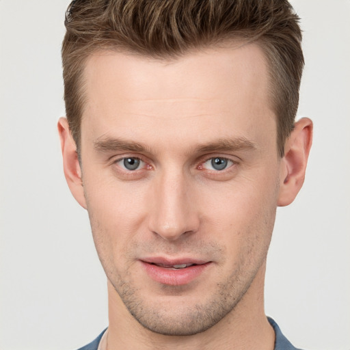 Joyful white young-adult male with short  brown hair and grey eyes