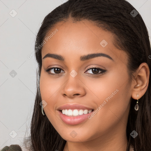 Joyful latino young-adult female with long  brown hair and brown eyes