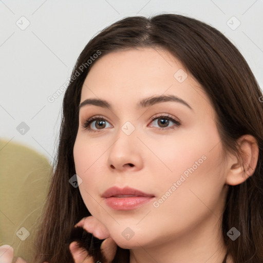 Neutral white young-adult female with long  brown hair and brown eyes