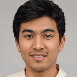 Joyful latino young-adult male with short  black hair and brown eyes