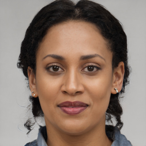 Joyful black adult female with long  brown hair and brown eyes