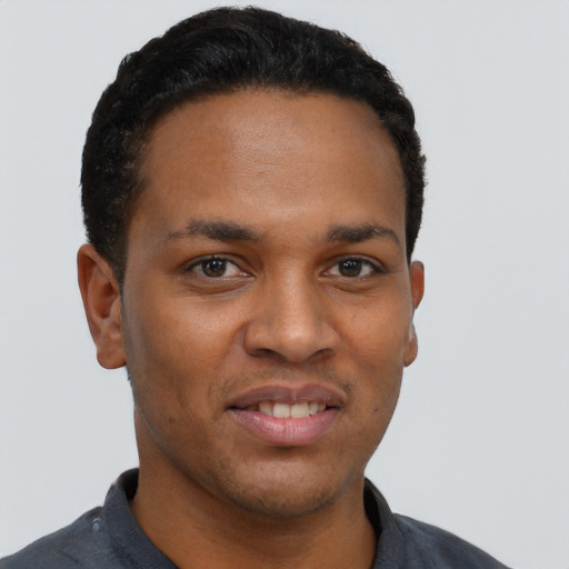 Joyful black young-adult male with short  black hair and brown eyes