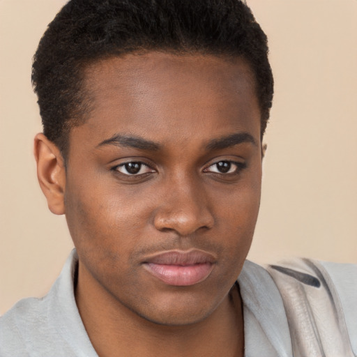 Joyful black young-adult male with short  brown hair and brown eyes