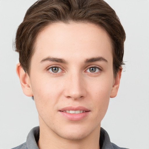 Joyful white young-adult male with short  brown hair and grey eyes