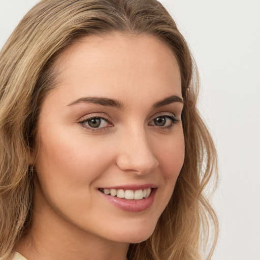 Joyful white young-adult female with long  brown hair and blue eyes