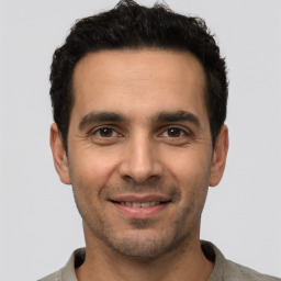Joyful white young-adult male with short  black hair and brown eyes