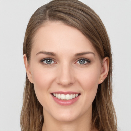 Joyful white young-adult female with long  brown hair and grey eyes