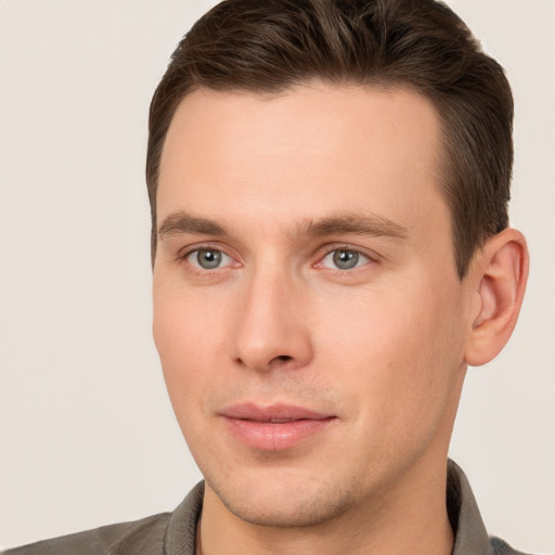 Joyful white young-adult male with short  brown hair and grey eyes