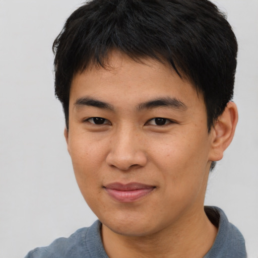 Joyful asian young-adult male with short  brown hair and brown eyes