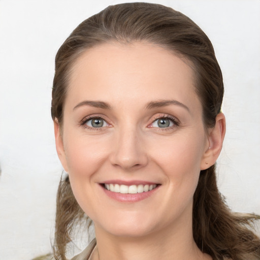 Joyful white young-adult female with long  brown hair and grey eyes