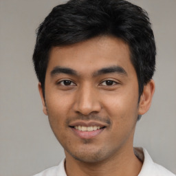 Joyful latino young-adult male with short  black hair and brown eyes