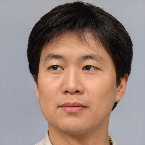 Joyful asian young-adult male with short  brown hair and brown eyes