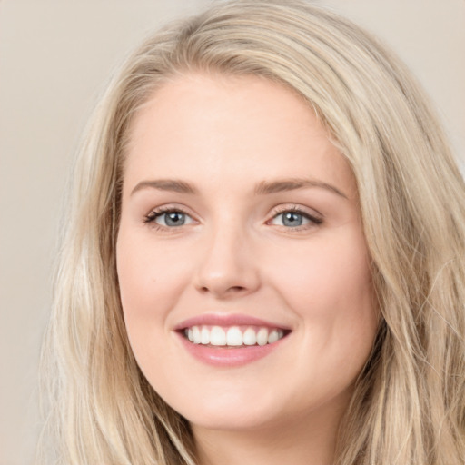 Joyful white young-adult female with long  brown hair and blue eyes