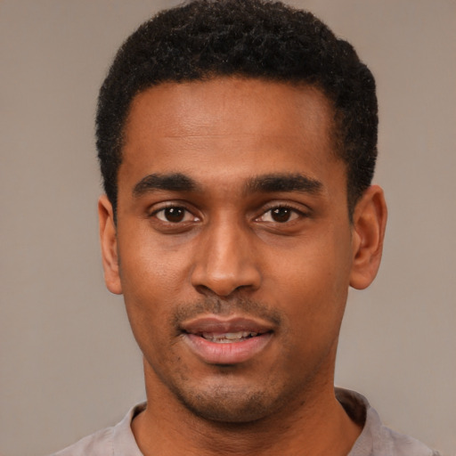 Joyful black young-adult male with short  black hair and brown eyes