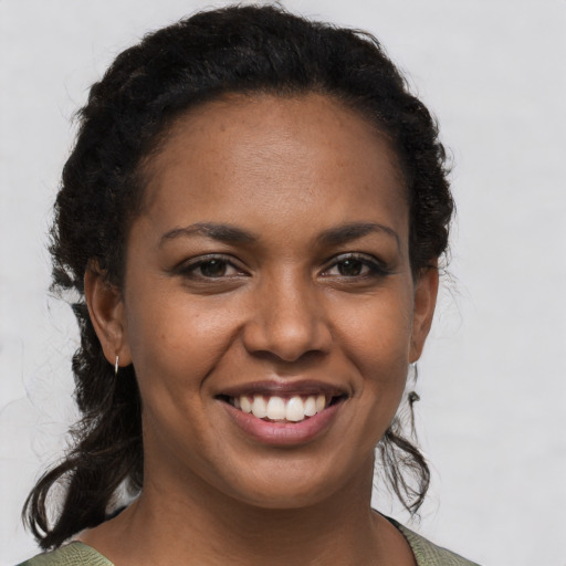 Joyful black young-adult female with short  brown hair and brown eyes