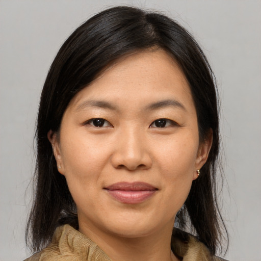 Joyful asian adult female with medium  brown hair and brown eyes