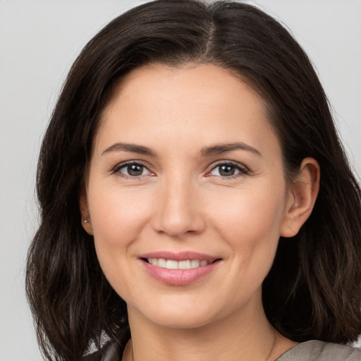 Joyful white young-adult female with long  brown hair and brown eyes