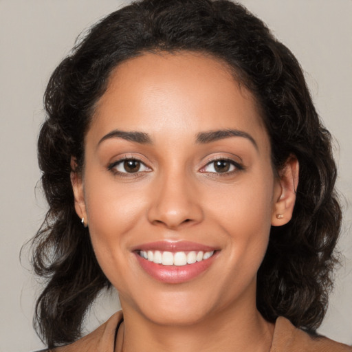 Joyful latino young-adult female with medium  brown hair and brown eyes