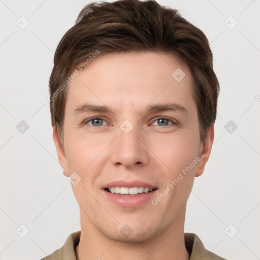 Joyful white young-adult male with short  brown hair and grey eyes