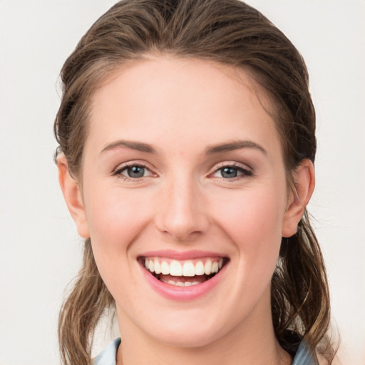 Joyful white young-adult female with medium  brown hair and grey eyes