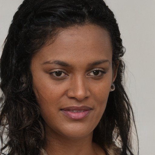Joyful black young-adult female with long  brown hair and brown eyes