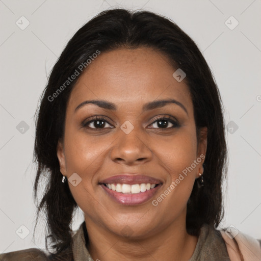 Joyful black young-adult female with long  brown hair and brown eyes